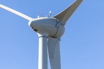 Detailed view of a wind turbine or wind mill, details at the main components: rotor blades, hub, nacelle and generator - obrazy, fototapety, plakaty