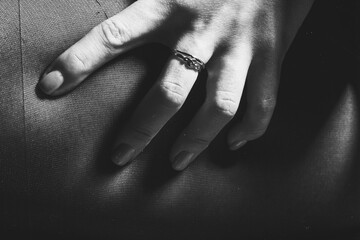 Abstract background of woman hand squeezing hip with fingers. Model wearing classic black...