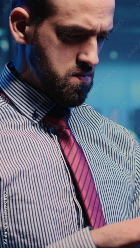Poster vertical video: data center it engineer standing next to server cabinets, activating hardware server
