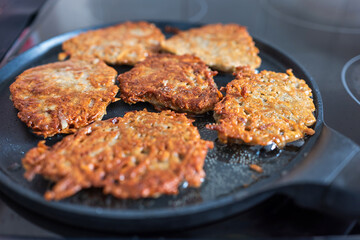 Frying crepe pancake pan with gratet potato on hot cooker hob