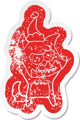 cartoon distressed sticker of a grinning fox wearing santa hat