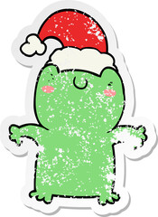 distressed sticker of a cute cartoon frog wearing christmas hat