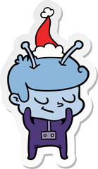 shy sticker cartoon of a spaceman wearing santa hat