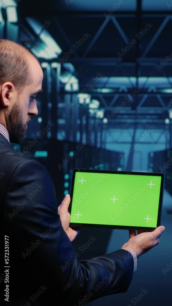 Poster vertical video: system engineer checking green screen display on tablet, running mainframe diagnosti