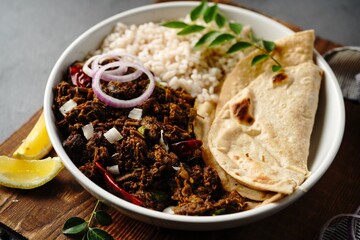 Homemade Kerala Beef Fry or Nadan beef roast served with boiled rice and roti