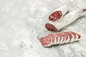 sausage fuet dried salami meat on a light background. banner, menu, recipe place for text, top view