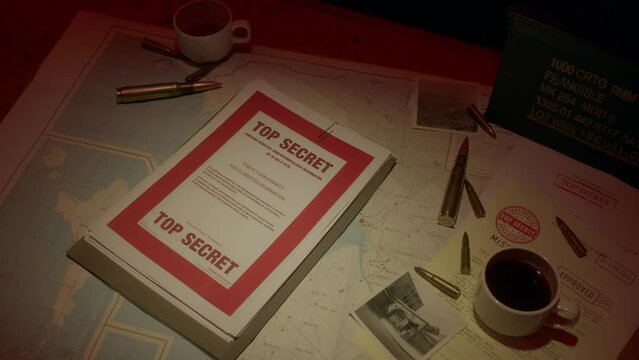 A retro manilla folder containing documents marked 'Top Secret' is seen on a wooden table lit by subdued light.