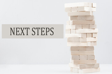 NEXT STEPS text with wooden block stack on white background , business concept