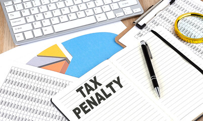 TAX PENALTY text on notebook with chart and keyboard