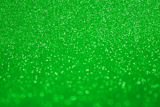 Abstract Glitter Background. Green Texture Sparkling Shiny Paper for Saint Patrick Day Holiday. Seasonal Wallpaper Decoration. Greeting and Wedding Invitation Card Design. Sparkle Light Bokeh Backdrop