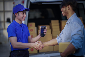 Deliver service. Man With Box in Car Outdoors Delivery Man in uniform holds parcel and phone car outdoors Delivery man taking parcels from The Delivery service