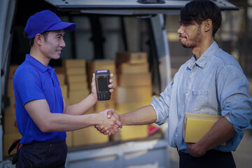 Deliver service. Man With Box in Car Outdoors Delivery Man in uniform holds parcel and phone car outdoors Delivery man taking parcels from The Delivery service