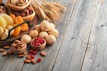 Tu Bishvat celebration concept. Mix of dry fruits and nuts almonds, hazelnuts, walnuts, apricots, prunes, cherries, raisins, dates, apples, figs over wooden table. Jewish holiday, new year of trees.