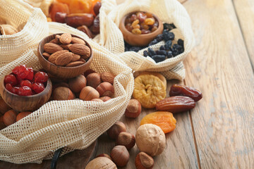 Tu Bishvat celebration concept. Mix of dry fruits and nuts almonds, hazelnuts, walnuts, apricots, prunes, cherries, raisins, dates, apples, figs over wooden table. Jewish holiday, new year of trees.