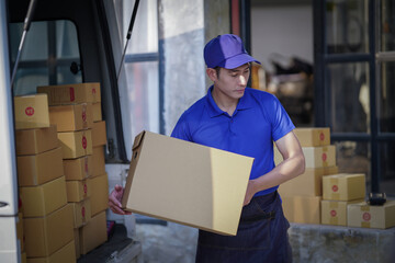 Deliver service. Man With Box in Car Outdoors Delivery Man in uniform holds parcel and phone car outdoors Delivery man taking parcels from The Delivery service