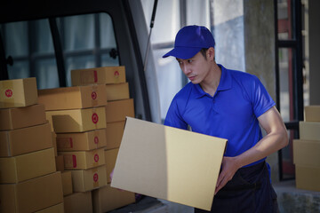 Deliver service. Man With Box in Car Outdoors Delivery Man in uniform holds parcel and phone car outdoors Delivery man taking parcels from The Delivery service