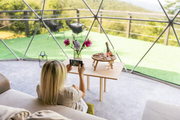 woman in interior of modern luxury glamping tent camp. Eco design concept, natural