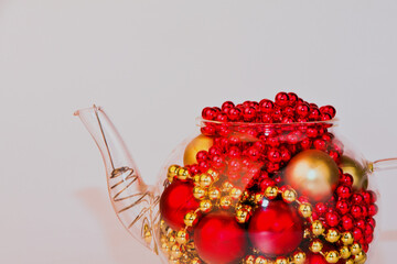 Christmas Cards Glass Teapot teapot with Christmas toys, cones and accessories.A candle is burning.Christmas tree.decor, with a Christmas tree and toys.on an isolated white background.place for text	