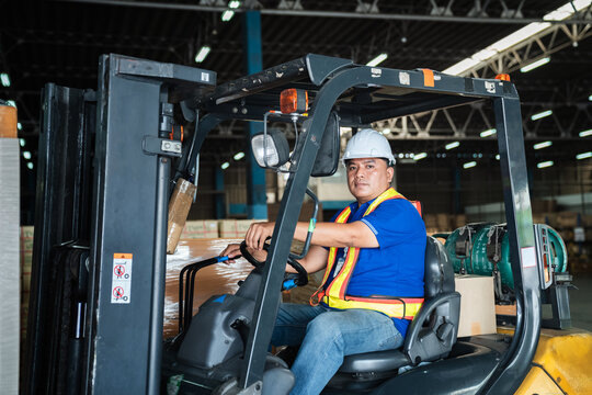 Warehouse worker workers with forklift in a warehouse. Use forklift operator moves packages. Concept industrial and commercial.