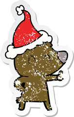 female bear distressed sticker cartoon of a wearing santa hat