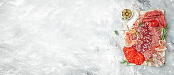 Meat platter appetizers on a light background. Long banner format. top view