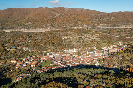 Aerial Drone view autumnal mountainous landscape "Ba&ntilde;os de Montemayor" village with sun, trees, plants and rocks in the north of Extremadura, Spain.