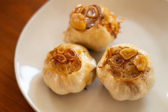 roasted garlic heads on a white plate
