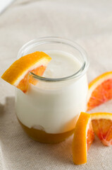 Macro Image of Nature Yogurt in a Small Glass Jar and Orange Slices