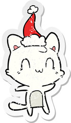 distressed sticker cartoon of a happy cat wearing santa hat