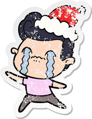 distressed sticker cartoon of a man crying wearing santa hat