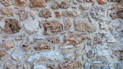 old stone wall made of sandstone blocks of different sizes as the background
