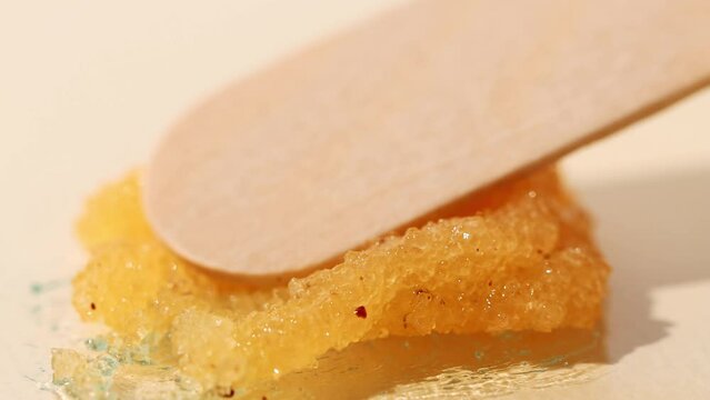 Sugar scrub with cleansing particles on a yellow background, cosmetic macro texture.