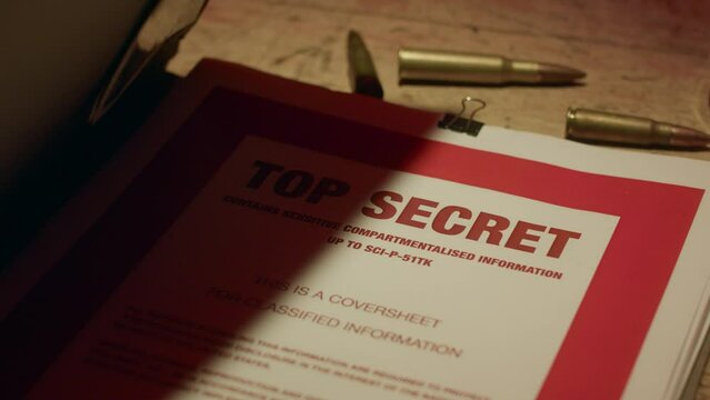 A retro manilla folder containing documents marked 'Top Secret' is seen on a wooden table lit by subdued light.