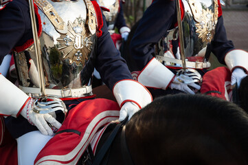 Soldados de caballería de la guardia real montados a caballo con coraza y sable durante un desfile.