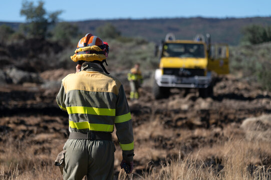 Un bombero forestal habla por tel&eacute;fono mientras se dirige hacia el cami&oacute;n de bomberos.