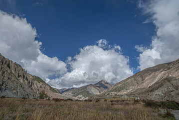 View of the high altitude plateau with Annapurna range in clouds (in the background) on the approach to Manang village, Manang district, Around Annapurna trek, Nepal Himalayas, Nepal