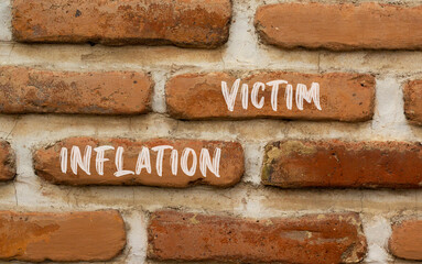 Inflation victim symbol. Concept words Inflation victim on red brown brick wall. Beautiful red brown brick wall background. Business inflation victim concept. Copy space.