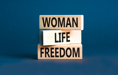 Woman life freedom symbol. Concept words Woman Life Freedom on wooden blocks on a beautiful grey table grey background. Social issue woman life freedom concept. Copy space.