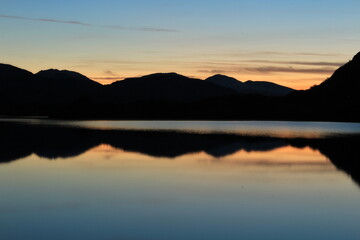 Fototapeta premium Stunning blue hour, twilight or dusk reflection over the Meeting of the Waters in Killarney National Park in winter. Close up view from popular stone lookout point on Ring of Kerry