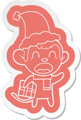 shouting cartoon  sticker of a monkey carrying christmas gift wearing santa hat