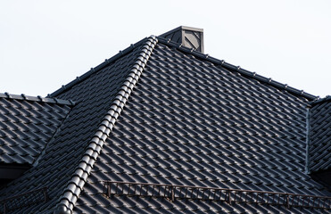 Fototapeta na wymiar A tile roof on a new house. Modern roof made of metal. Modern house construction