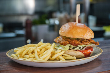 A tasty looking KFC style breaded chicken burger served alongside French Fries