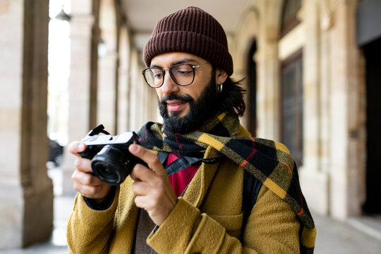 Handsome man travelling with a camera in old city - Holidays, tourism and travel concept