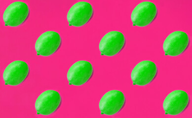 Green lemon on the bright pink background. Flat lay. Pattern. Top view.