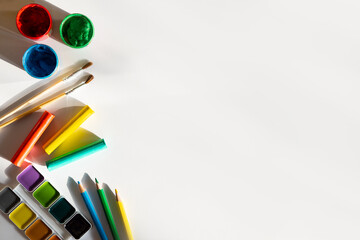 Empty paper with paints, brushes, pencils. Copy space for text.