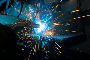 Industrial steel welder in a factory. Welder at work.