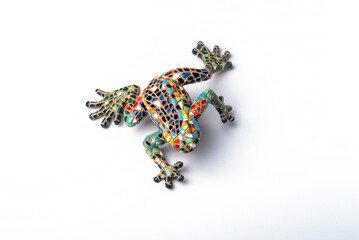 Frog figurine, decorated in the style of Gaudi from small pieces of tiles on white background....