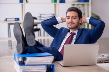 Young male employee and too much work in the office