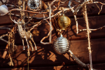 New Year's decoration on tree branches near a wooden wall