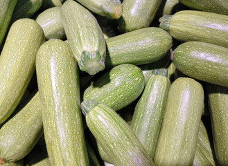 Background of fresh zucchini on a shop window. Group of objects
